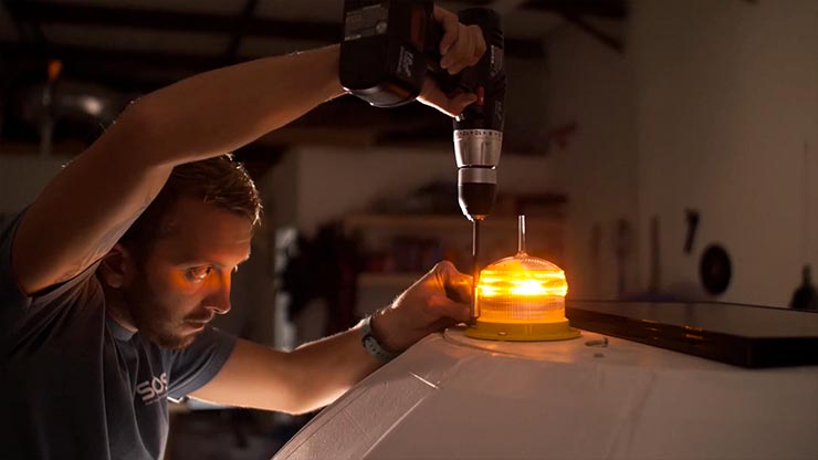 A blurry orange sunset above water with a white horizontal logo across the image