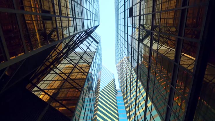 Buildings with reflections of nearby buildings from the ground looking up