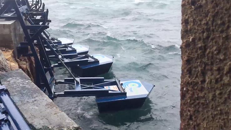 Blue marine energy devices connected to a structure floating in the ocean.