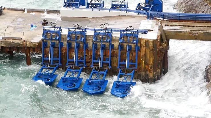 Four blue marine energy devices attached to a structure floating in the water.