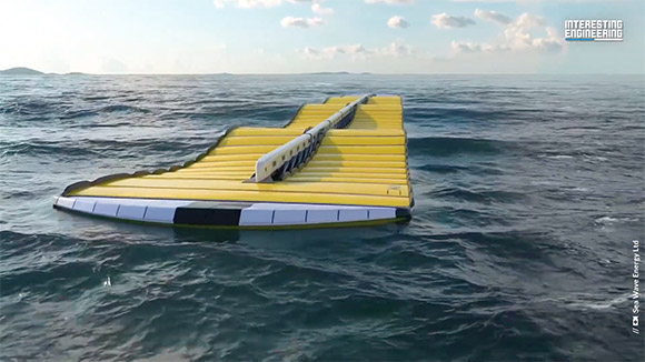 A long, yellow marine energy device floating on the ocean surface.