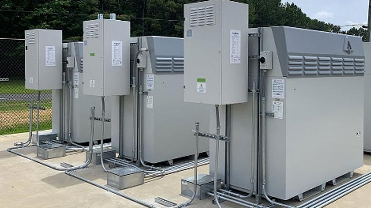 A photo of gray battery systems connected by cables in rows